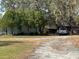Home featuring mature landscaping, an outbuilding, and a vehicle in the driveway at 31029 Nocatee Trl, Sorrento, FL 32776
