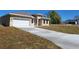Lovely tan single-Gathering home with a two-car garage and a paved driveway amidst a green lawn at 4655 Sw 139Th Ln, Ocala, FL 34473