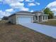 Charming single-story home with a neutral color, attached two-car garage, and well-manicured lawn at 4655 Sw 139Th Ln, Ocala, FL 34473