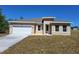 Inviting tan single-Gathering home featuring a two-car garage, green lawn and a well-lit entryway at 4655 Sw 139Th Ln, Ocala, FL 34473