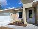 Inviting front entrance with white trim, a classic white door, and neat landscaping with mulched flowerbed at 4655 Sw 139Th Ln, Ocala, FL 34473