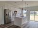 Modern kitchen with white cabinets, stainless steel appliances, and a center island with pendant lighting at 4655 Sw 139Th Ln, Ocala, FL 34473