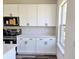 Modern kitchen showcasing white cabinets, quartz countertops, and stainless steel appliances at 4655 Sw 139Th Ln, Ocala, FL 34473