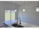 Quartz countertop with a stainless steel sink and matte black faucet overlooking backyard at 4655 Sw 139Th Ln, Ocala, FL 34473
