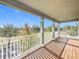 A bright and airy balcony with wood-look flooring and a white railing offers views of the surrounding trees and blue skies at 12285 Joshua Tree Trl, Windermere, FL 34786