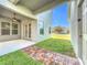 A covered outdoor patio features a ceiling fan, access to the lawn, and view of the adjacent house at 12285 Joshua Tree Trl, Windermere, FL 34786