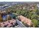 Beautiful aerial view of townhomes with a serene pond, surrounded by a dense forest and vibrant greenery at 1300 Gilford Point Ln # 1300, Davenport, FL 33896