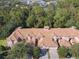 An up-close aerial view of a townhome with lush greenery, tall trees, and well-maintained lawns at 1300 Gilford Point Ln # 1300, Davenport, FL 33896
