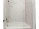 White bathtub and shower combination featuring white marble tiling at 2097 Celebration Blvd, Celebration, FL 34747