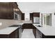 Modern kitchen featuring stainless steel appliances, dark wood cabinets, and white marble countertops at 2097 Celebration Blvd, Celebration, FL 34747