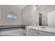 Bathroom with corner bathtub, gray tile, and vanity with white cabinets at 2102 Kingswood Ave, Deltona, FL 32725