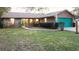 Brick ranch home with a teal garage door and a landscaped lawn at 3021 Norvell Ct, Deltona, FL 32738