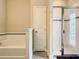 Modern bathroom featuring a soaking tub, glass-enclosed shower, and neutral tones at 5303 Wildwood Way, Davenport, FL 33837