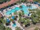 Wide aerial shot of a community pool area featuring multiple pools, water slides, and lounge areas at 5303 Wildwood Way, Davenport, FL 33837