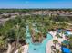 Aerial view of a lazy river winding through a community with lush landscaping and blue umbrellas at 5303 Wildwood Way, Davenport, FL 33837