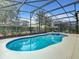 Inviting private pool surrounded by lush landscaping within a screened enclosure at 5303 Wildwood Way, Davenport, FL 33837