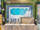 Aerial view of a screened-in pool and hot tub with lounge chairs, surrounded by manicured landscaping at 5303 Wildwood Way, Davenport, FL 33837