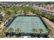 Aerial view of two tennis courts, surrounded by palm trees and lush landscaping in a community at 5303 Wildwood Way, Davenport, FL 33837