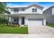 Charming two-story home with manicured lawn, brick driveway, and inviting front porch seating at 159 Golden Noble St, Kissimmee, FL 34747