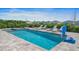 Inviting pool area with hot tub, lounge chairs, lush greenery, and neighborhood view at 159 Golden Noble St, Kissimmee, FL 34747