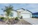 White one-story house with a two-car garage and landscaped front yard at 1678 Hideaway Flat St, Mascotte, FL 34753