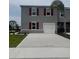 Charming two-story home featuring a well-kept lawn, gray exterior, red shutters, and a concrete driveway at 2729 Golden Trout Ln, Edgewater, FL 32141