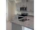 This is a spacious kitchen with stainless steel appliances, granite counters, grey cabinets, and a modern sink at 2729 Golden Trout Ln, Edgewater, FL 32141