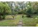 A peaceful backyard featuring lush greenery, mature trees, and a stone walkway at 306 Wild Olive Ln, Longwood, FL 32779