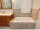 Bathroom featuring vanity and soaking tub with a tile surround at 306 Wild Olive Ln, Longwood, FL 32779