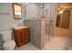 Bathroom boasts tiled walk-in shower with glass door and a classic wood vanity at 306 Wild Olive Ln, Longwood, FL 32779