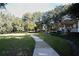 A beautiful front yard with winding sidewalk, lush landscaping, and mature trees at 306 Wild Olive Ln, Longwood, FL 32779