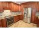 Spacious kitchen featuring wooden cabinets, stainless steel appliances, and granite countertops at 306 Wild Olive Ln, Longwood, FL 32779