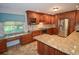 The kitchen boasts custom cabinetry, granite countertops, a center island, and modern stainless appliances at 306 Wild Olive Ln, Longwood, FL 32779