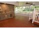 Large screened lanai boasts outdoor kitchen with sink, wood floors and a ceiling fan at 306 Wild Olive Ln, Longwood, FL 32779