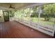 Relaxing screened porch with wood floors and ceiling fan overlooking a beautiful, lush backyard at 306 Wild Olive Ln, Longwood, FL 32779