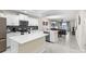 Modern kitchen with white cabinetry, stainless appliances, and an island featuring light countertops and an open concept living area at 4721 Clock Tower Dr # 204, Kissimmee, FL 34746