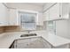 Modern kitchen with white cabinets, quartz countertops and double sink at 1748 Haverhill Dr, Deltona, FL 32725