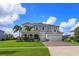 Two-story house with solar panels, landscaped yard, and a paved driveway at 4150 Sunset Preserve Blvd, Orlando, FL 32820