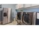 Modern laundry room with stainless steel appliances and ample storage at 4150 Sunset Preserve Blvd, Orlando, FL 32820