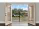 View from the balcony through French doors showcases the neighborhood and beautifully landscaped yards at 10852 Mobberley Cir, Orlando, FL 32832