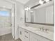 Bathroom with dual sinks, white cabinets, and a bathtub with a shower and tiled surround at 10852 Mobberley Cir, Orlando, FL 32832