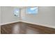 This bedroom features dark, hardwood flooring and abundant natural light from two windows at 10852 Mobberley Cir, Orlando, FL 32832