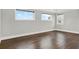 A bright bedroom is showcased with hardwood floors and lots of natural light from the three windows at 10852 Mobberley Cir, Orlando, FL 32832