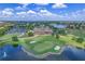 Scenic aerial view of a community golf course showcasing the clubhouse, water features, and lush landscaping at 10852 Mobberley Cir, Orlando, FL 32832