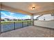 This covered patio boasts a serene view of the tennis court and adjacent green areas and landscaping at 10852 Mobberley Cir, Orlando, FL 32832