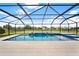 A pristine screened-in pool area with a tiled waterfall feature and ample space for lounging and entertaining at 10852 Mobberley Cir, Orlando, FL 32832