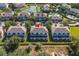 Enjoy this aerial view of attractive townhomes with screened lanais, lush landscaping, and community amenities including a pool and playground at 17417 Placidity Ave, Clermont, FL 34714