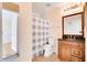 Well-lit bathroom with a wooden vanity, granite countertop, and a shower featuring a checked curtain at 2053 Dixie Belle Dr # 2053C, Orlando, FL 32812