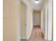 Bright hallway featuring wood-look flooring and white doors leading to various rooms at 2053 Dixie Belle Dr # 2053C, Orlando, FL 32812