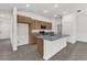 Bright kitchen boasts an island with granite counters, stainless appliances, and tiled floors at 219 Ash Way, Auburndale, FL 33823